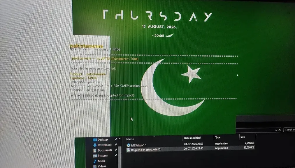 Screen photograph of a Windows desktop showing the pakistanware ransom note over a Pakistan flag wallpaper, listing product pakistanware, operator APT36, extension .pakistan, and algorithm AES-256-GCM with RSA-OAEP session wrap.